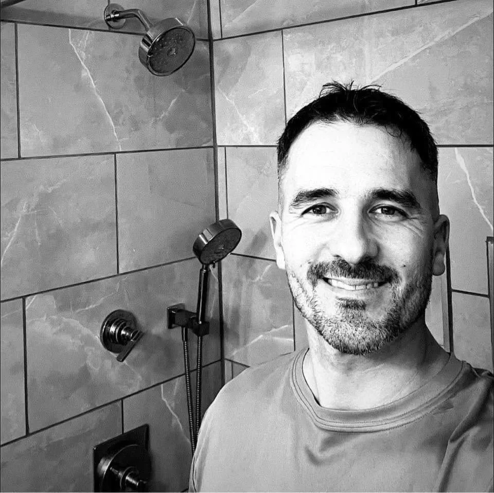 Frank Karichko beside tiled shower fixtures