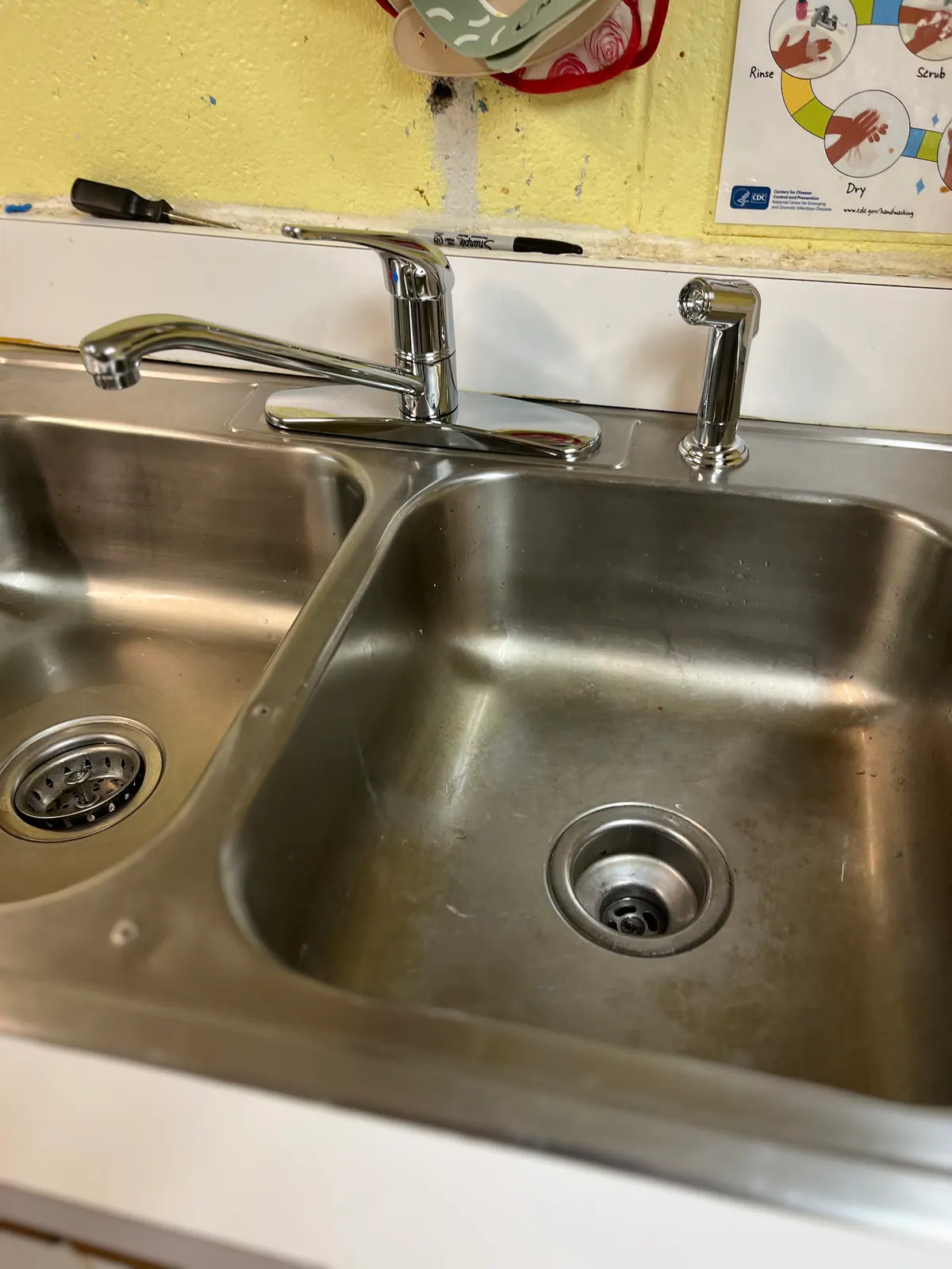 Chrome faucet and side sprayer on a stainless steel double sink